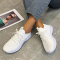 Women's low-top running shoes in creamy white with Flyknit upper and lace-up closure