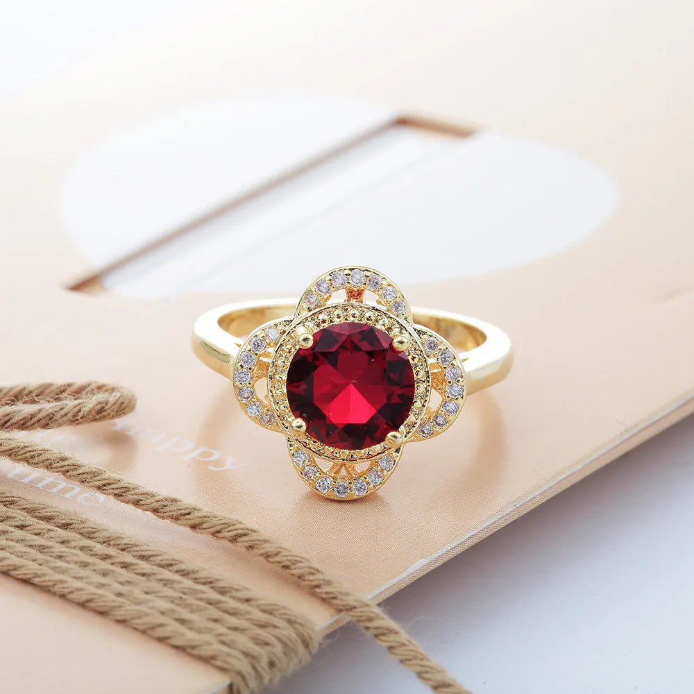 Copper ring with geometric fruit shape and zircon inlay detail on a grey background.