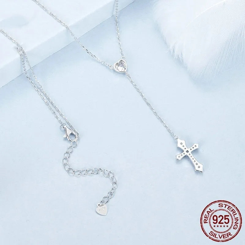 Close-up of a silver love cross necklace with an adjustable O-ring chain on an antique BSN384 finish.