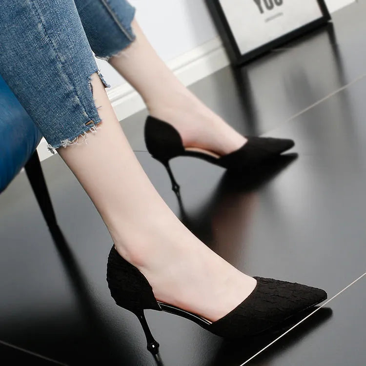 Women's black pointed high heel shoes with stiletto heel on neutral background