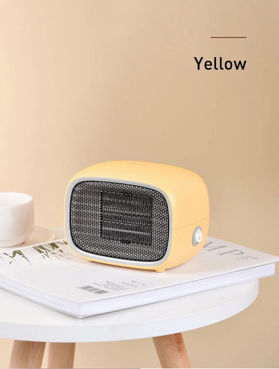 Green mini PTC ceramic heater with metal mesh front on a wooden desk