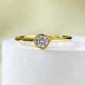 Minimalist crown shape silver ring electroplated in gold or platinum colour on a plain background.