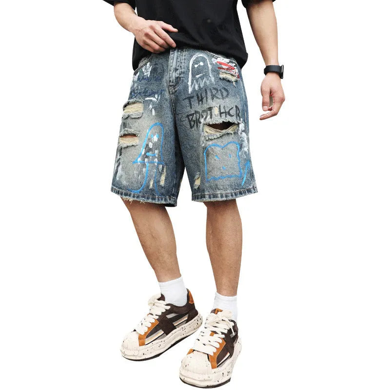 Blue mens denim shorts with ripped knees and graffiti design, straight leg fit.