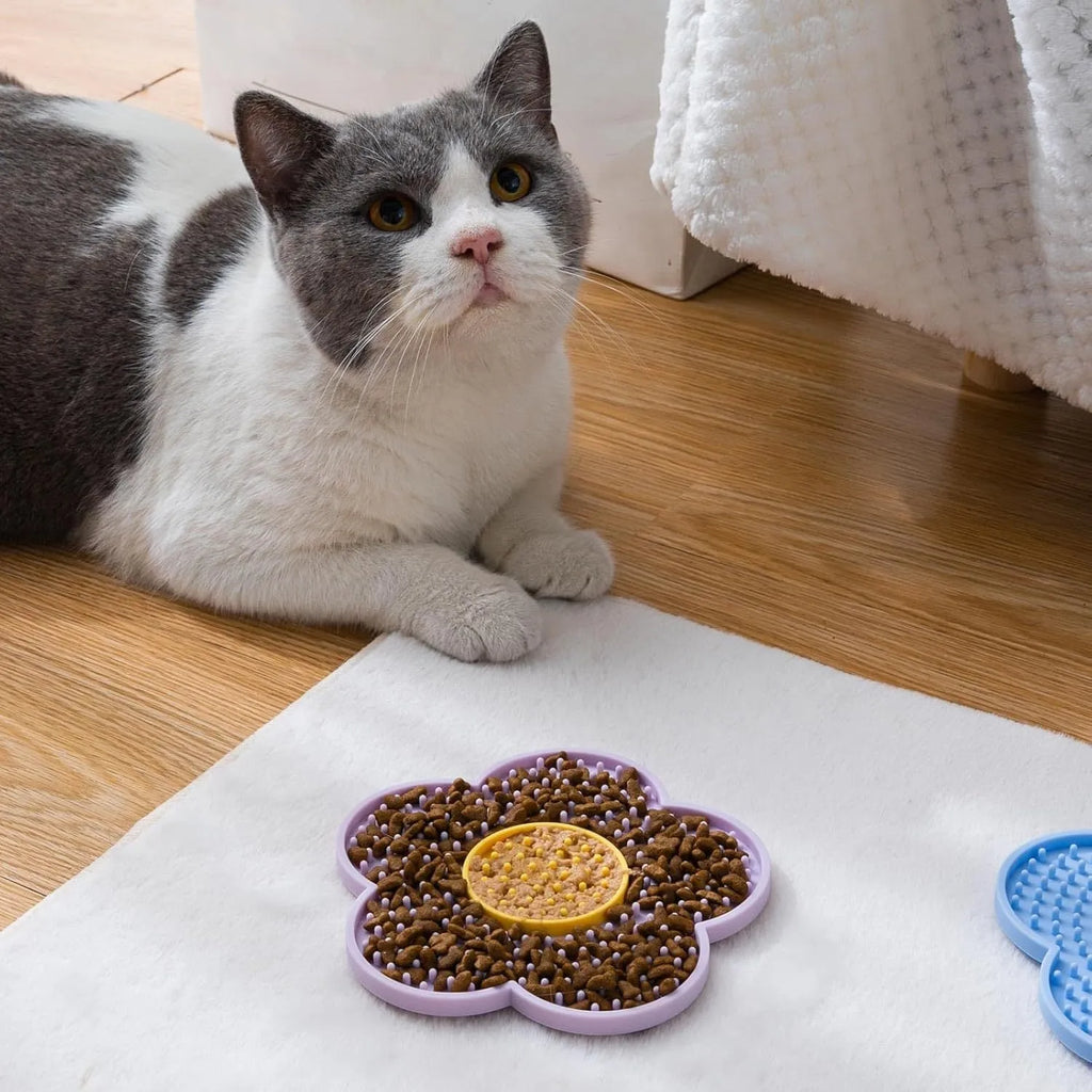 Flower-shaped blue silicone pet lick mat with suction cups on a smooth surface