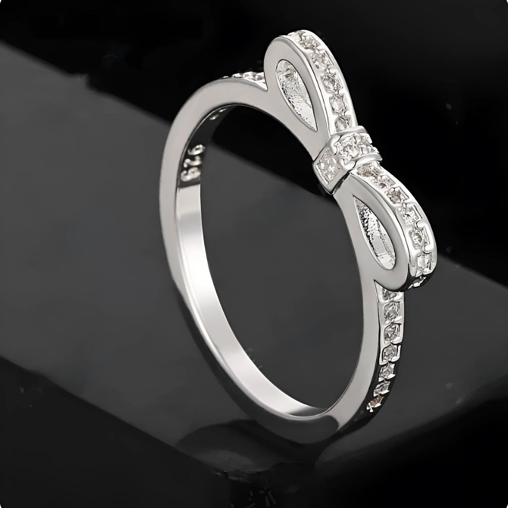 Silver bow ring with zircon crystal and rhinestone detailing on finger
