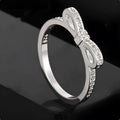 Silver bow ring with zircon crystal and rhinestone detailing on finger