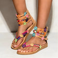 Women's ethnic beaded petal Roman sandals with round toe on a light background.
