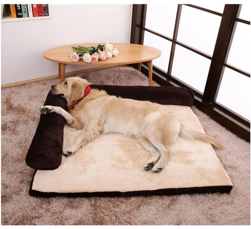 Corduroy dog sofa bed with bolster, shown in grey, placed on a wooden floor.
