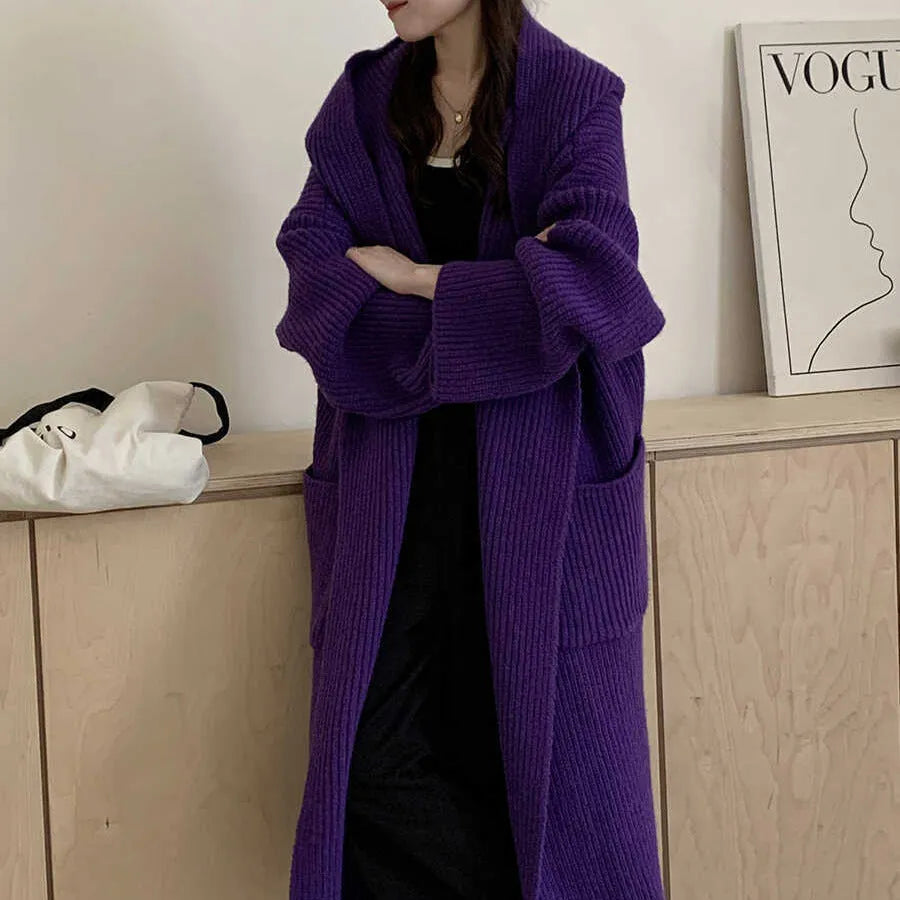 A woman wearing a longline milky white hooded cardigan sweatshirt with raglan sleeves.