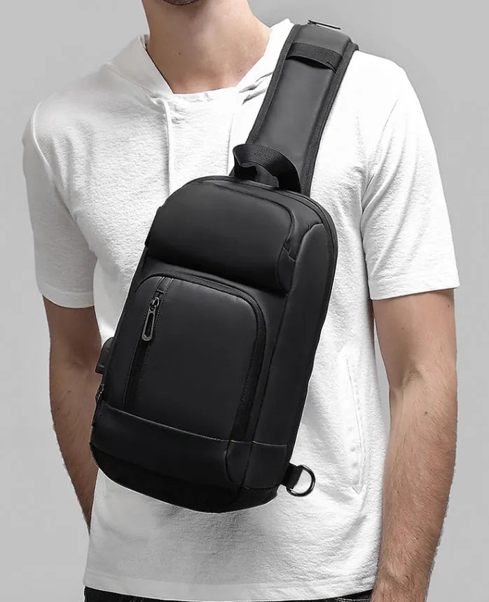 Black PVC outdoor shoulder bag with air cushion strap showing internal computer pocket and organisational compartments