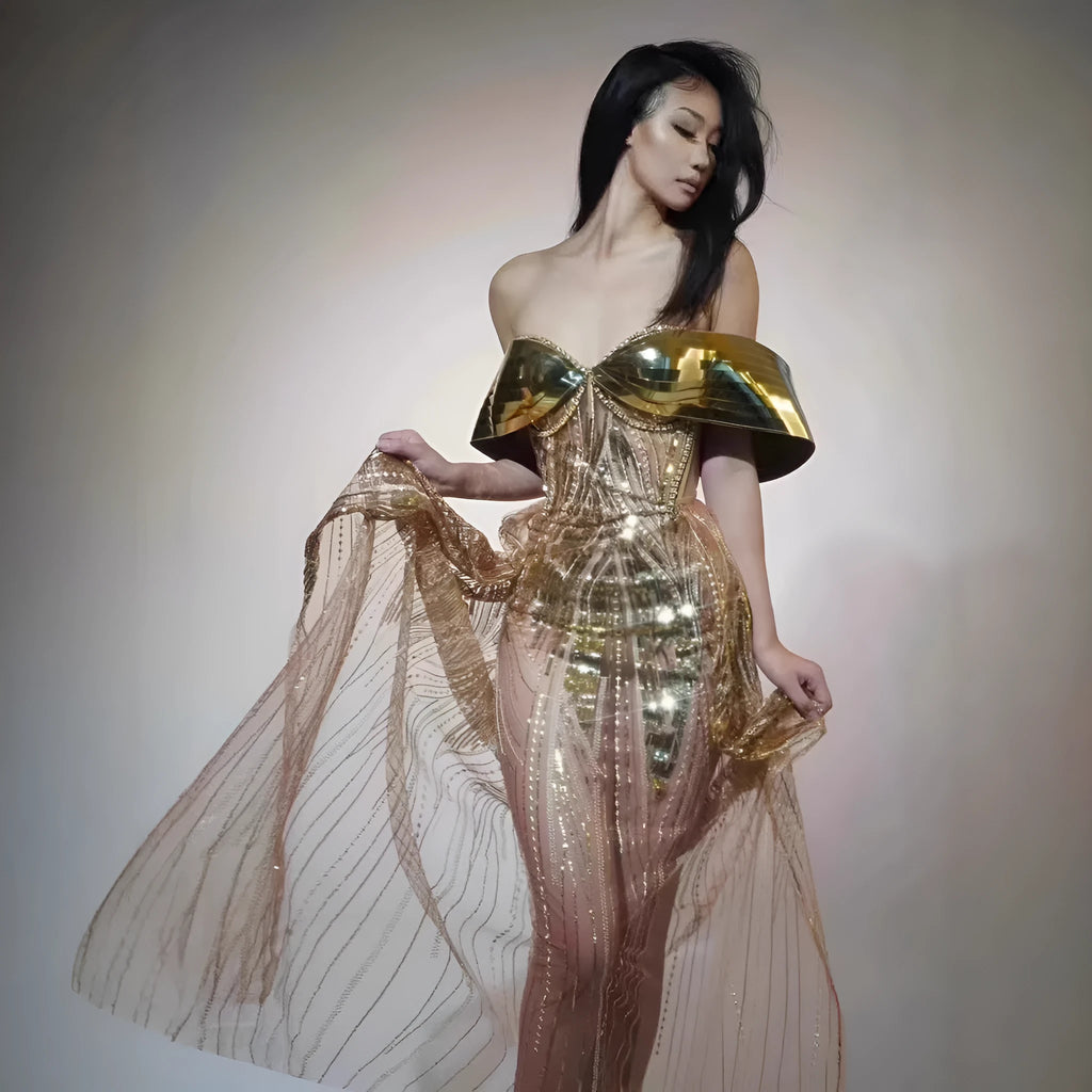Gold sequinned strapless long evening dress with a high thigh split on a model.