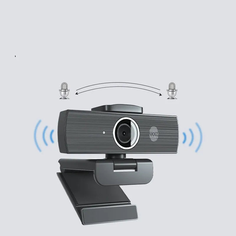 Black USB computer webcam with attached cable and magnetic privacy cover on a desk