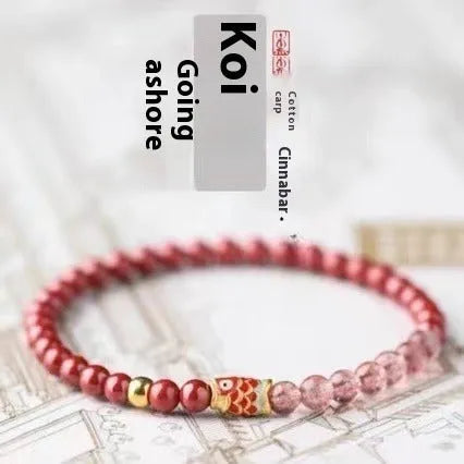 Purple cinnabar and strawberry quartz bracelet with koi and peach blossom design on a wrist.