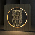 Tooth-shaped wood colour acrylic table lamp with USB cable on a wooden surface.