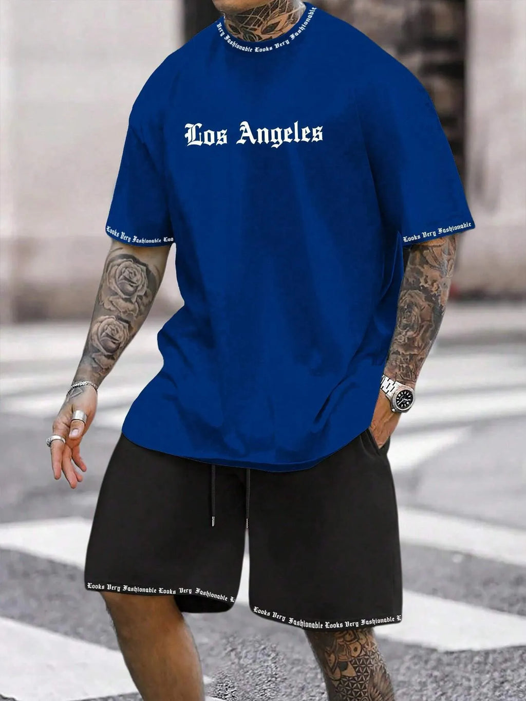 Man wearing a grey short-sleeve top and matching shorts from a sports co-ord set.