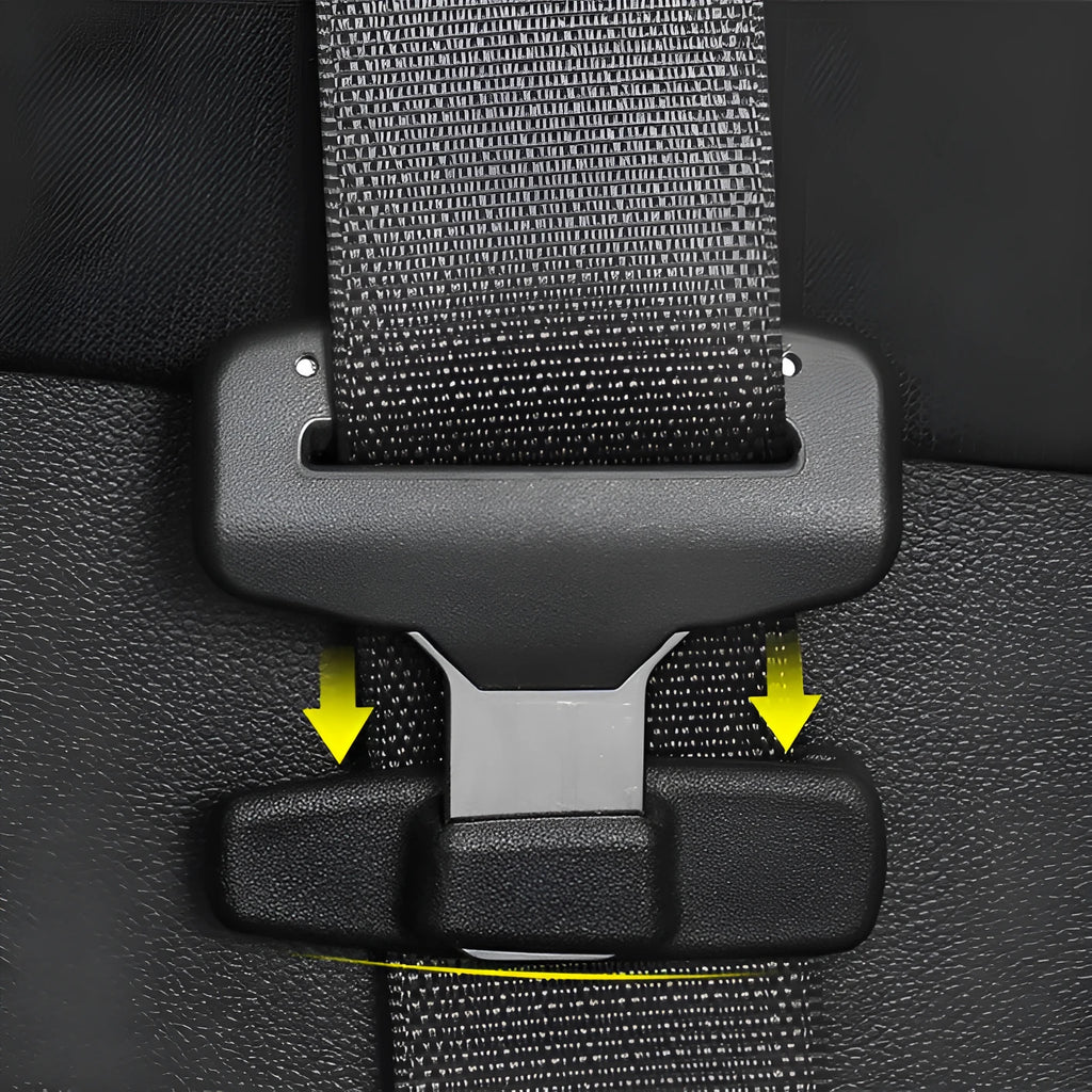 A pair of black plastic universal seat belt stopper clips on a car seat.