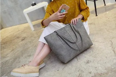 Simple fashion shoulder bag with adjustable strap shown in black and grey colour options