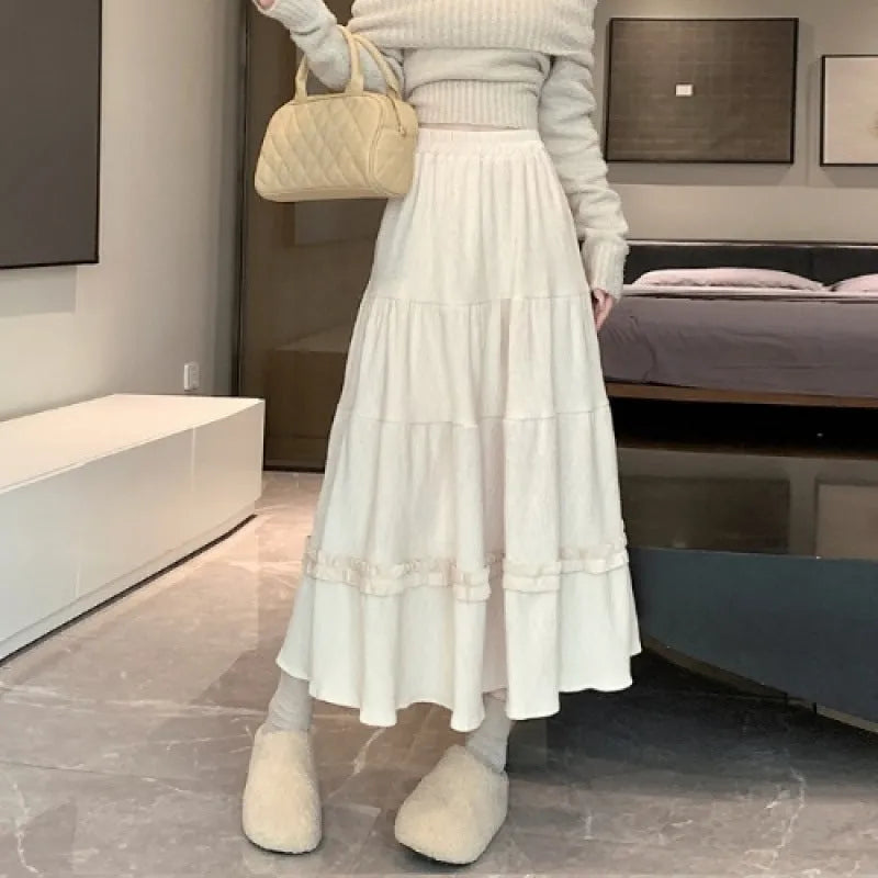 Korean style beige corduroy A-line midi skirt with an elastic waistband on a hanger.