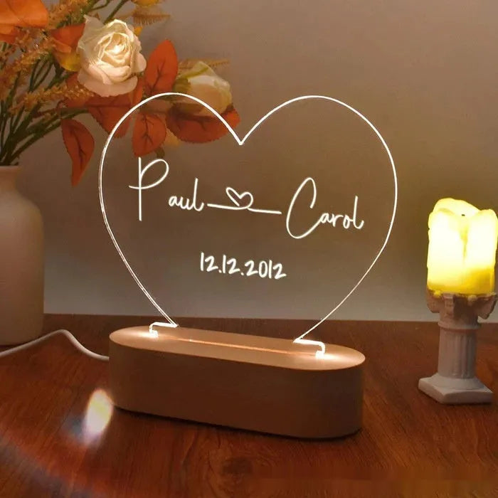 Custom clear acrylic night light with engraved names, lit by an LED base.