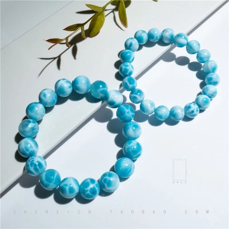Blue natural crystal sea-pattern stone and bodhi seed bracelet with pearl accents on a wrist.