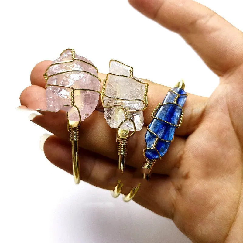 Unisex rough natural crystal bracelet with geometric gold metal winding on a wrist