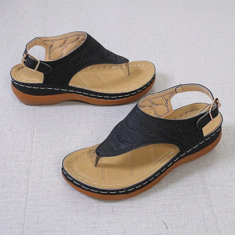 Women's wedge heel flip flop sandals in black with an adjustable back strap and buckle.