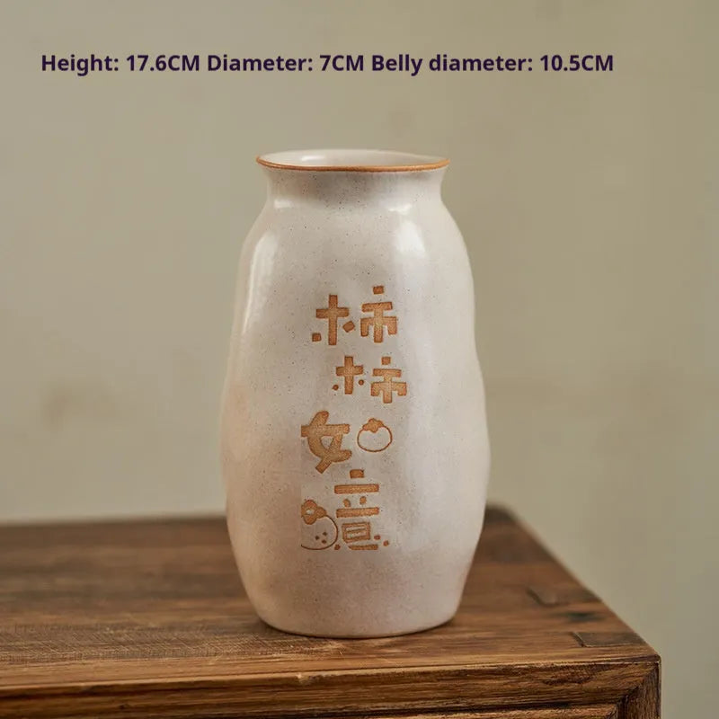 Chinese hand-painted ceramic vase with carved design on wooden desktop