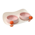 Pink ceramic double pet bowl set with raised non-slip base for cat food and water.