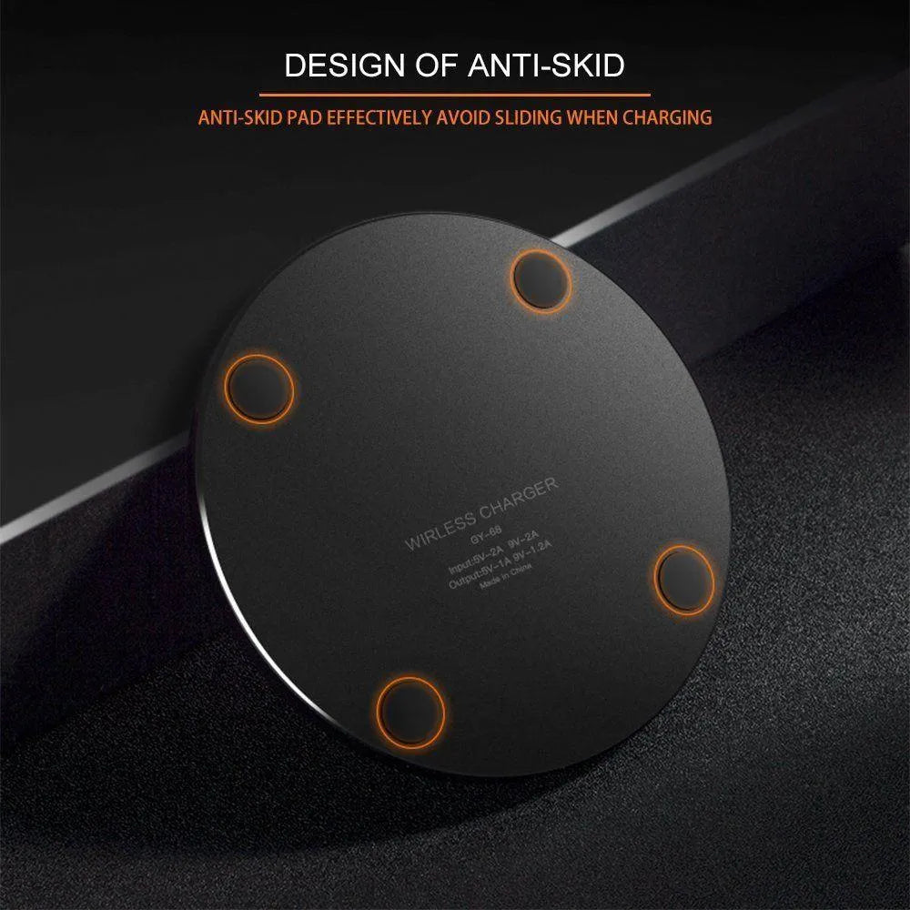Black ultra-thin 9V QI wireless fast charger with USB cable on a desk.