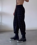 Men's plaid trousers with apron waist design showing front overlap detail