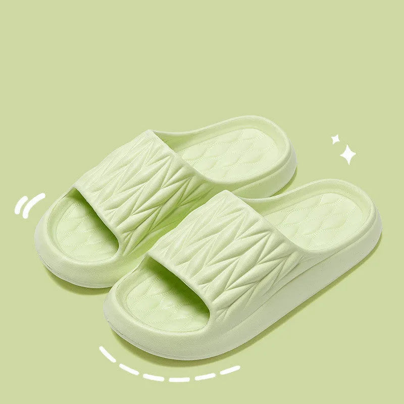Pair of grey EVA foam slippers with leaf texture pattern and non-slip sole.