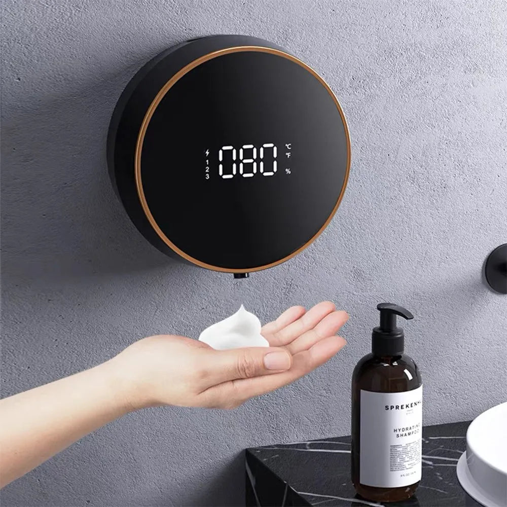 Black automatic sensor foam soap dispenser mounted on a bathroom wall with USB charging cable.