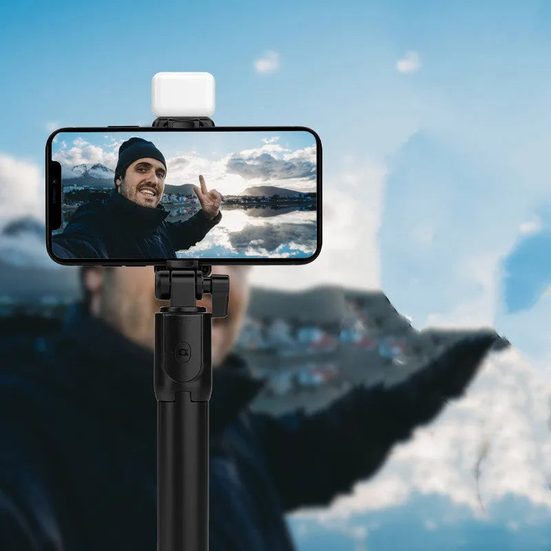 Black Bluetooth selfie stick with tripod base and phone holder, shown extended, for use with Apple iPhones.