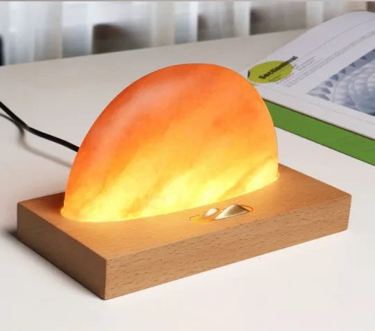 Sunrise Oriental table lamp with natural salt shade on wood base, showing wireless phone charging.