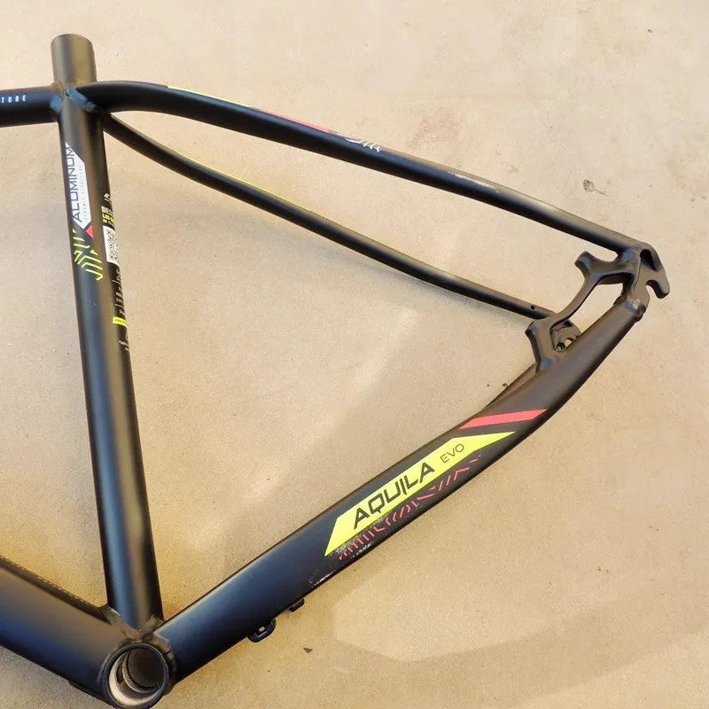 Black green aluminium mountain bike frame for 29-inch wheels with disc brake mounts and internal cable routing ports.