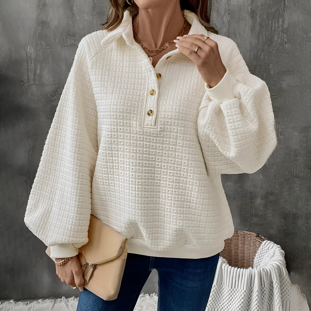 Beige women's knitted sweater with a polo collar and long sleeves laid flat.