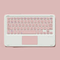 Pink Bluetooth wireless touch keyboard and rechargeable mouse combo on a desk next to a tablet
