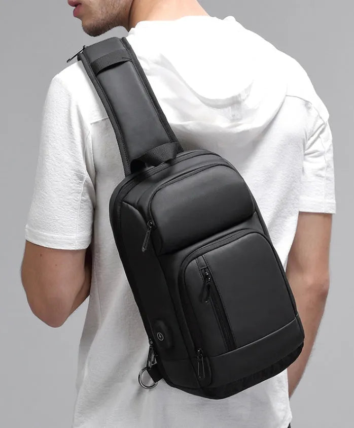 Black PVC outdoor shoulder bag with air cushion strap showing internal computer pocket and organisational compartments