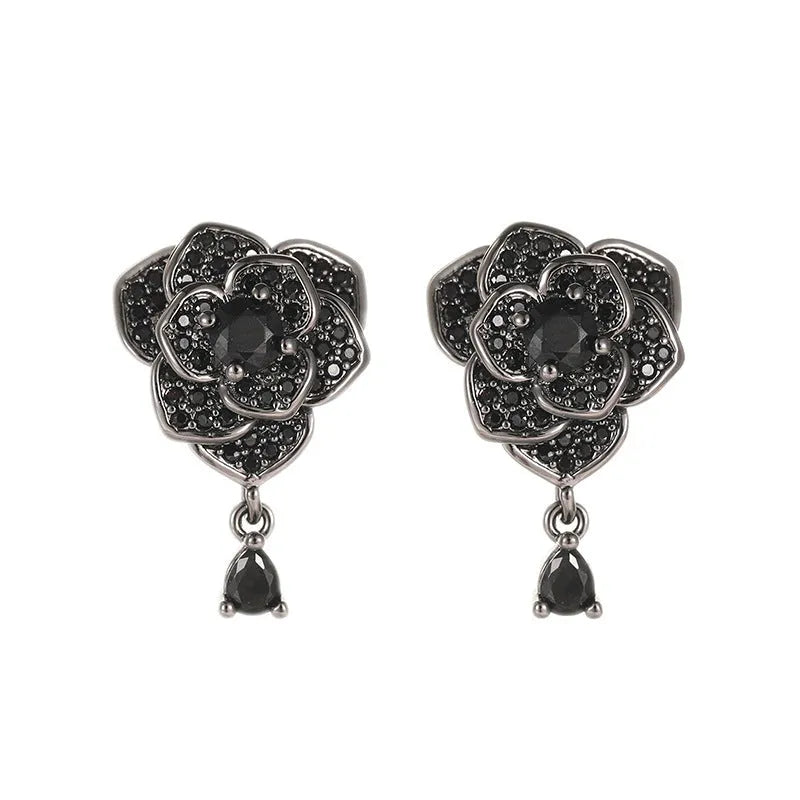 Close-up of women's floral stud earrings with a black rose zircon stone and gold electroplated finish.