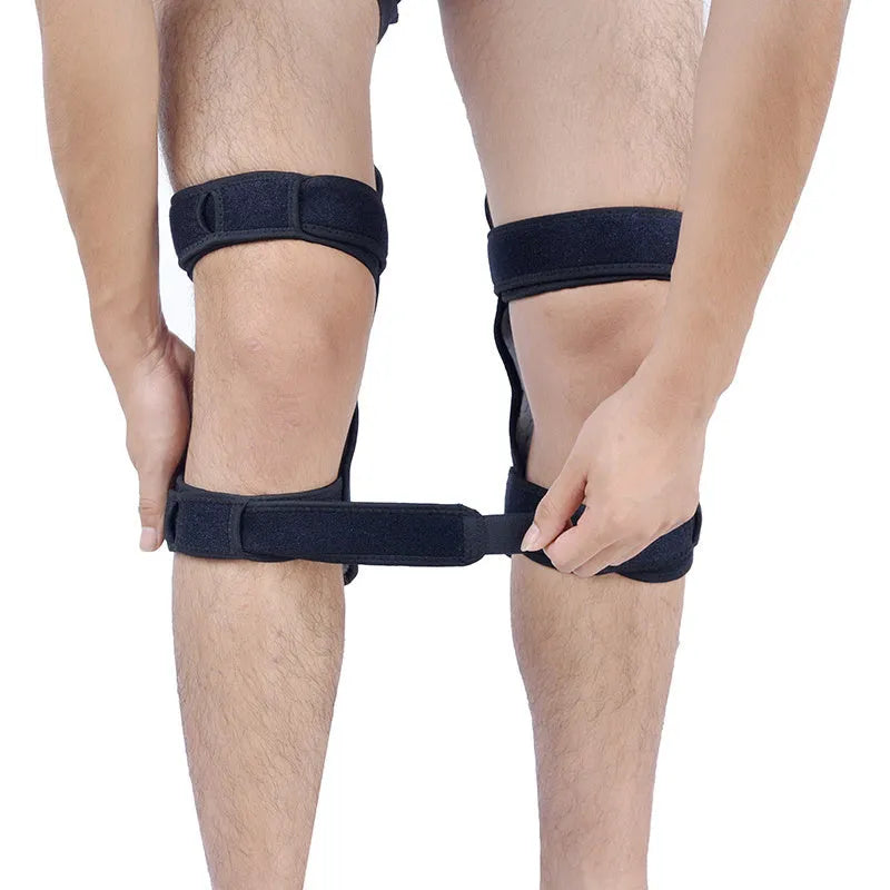 Adjustable spring knee brace in black, shown on a leg, featuring breathable fabric and venting holes for sports support.