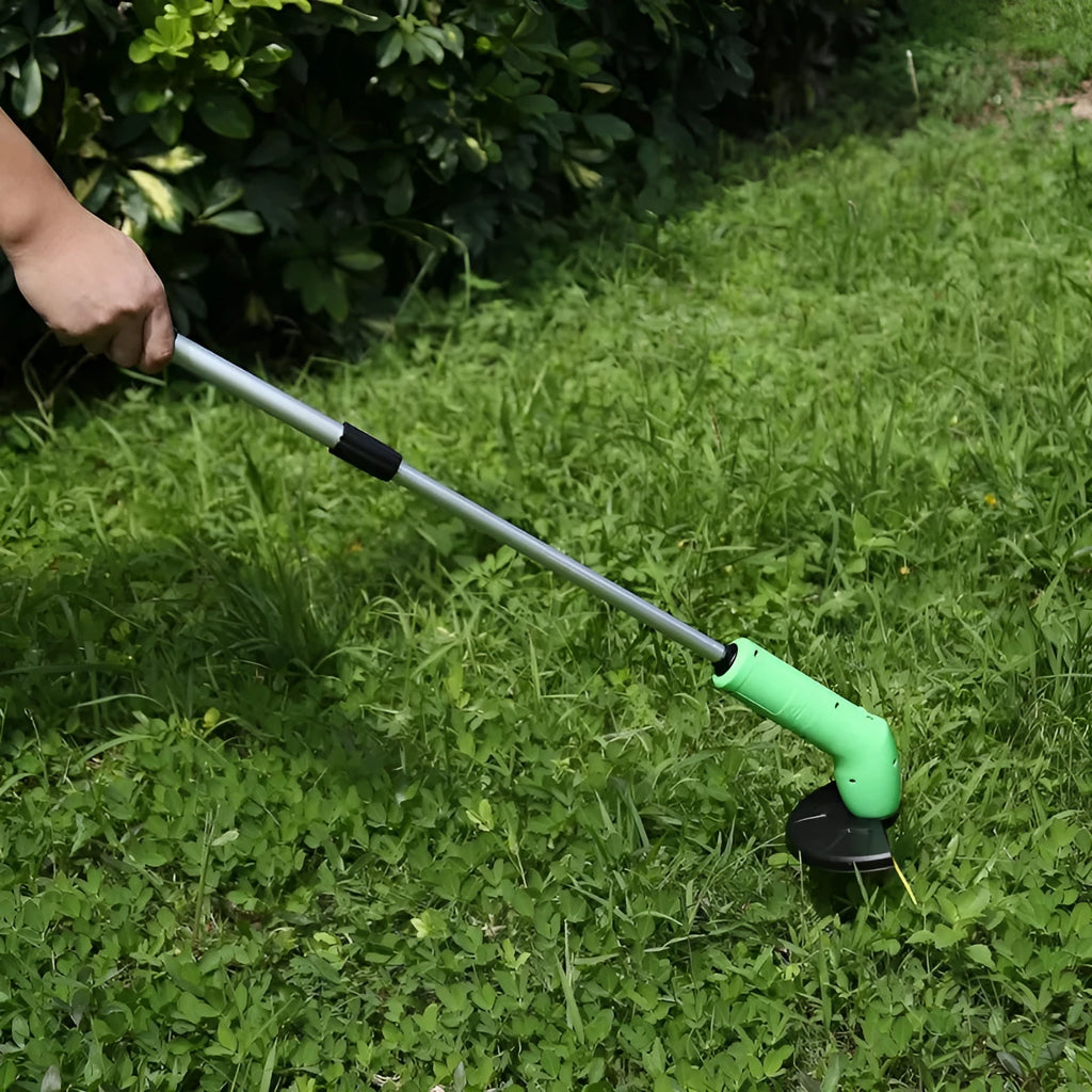 Cordless electric lawn trimmer with extension pole and black debris shield on a green lawn.