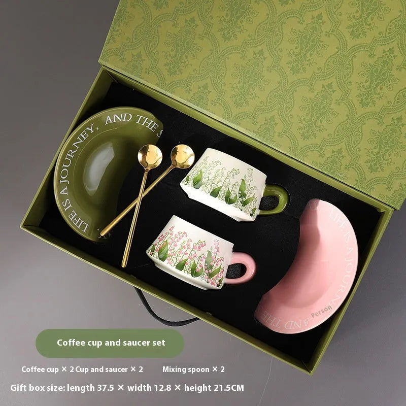 Ceramic coffee cup and saucer set for two with couple's design and stirring spoons