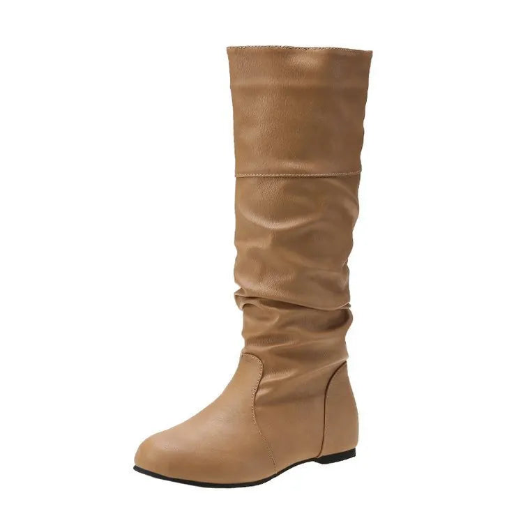 Women's black slip-on flat long boots with a round toe and high shaft on a neutral background.