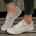 Women's low-top creamy white fabric sneakers with a wear-resistant rubber sole on a neutral background.