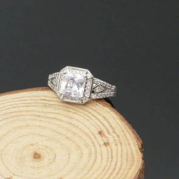 Platinum-colour zircon ring with hollow geometric quadrilateral design on a copper base