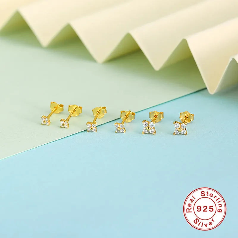 S925 sterling silver stud earrings with crystal flowers in gold and platinum finishes on a grey background.