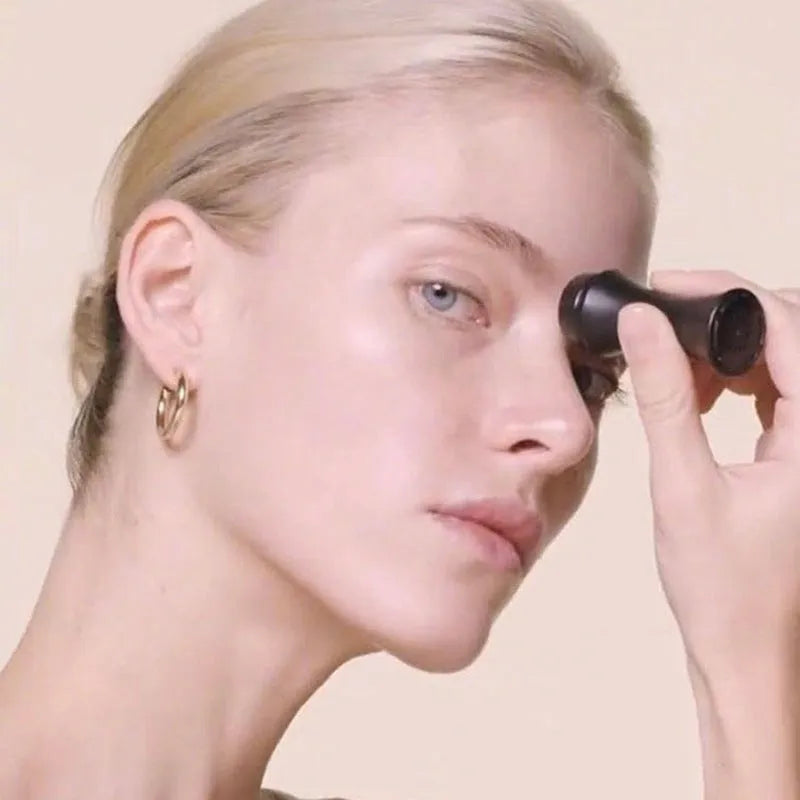 Portable volcanic stone oil-absorbing facial roller in black, green, pink, or white on a plain background.