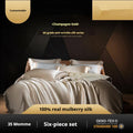 Solid colour silk four-piece quilt cover set shown in a light luxury bedroom setting.