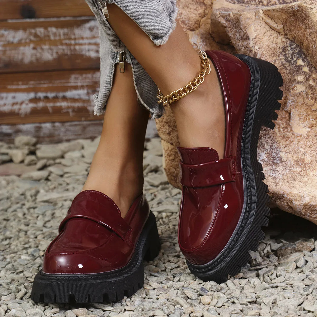 Women's black chunky heel slip-on loafers with a platform sole, shown on a foot.