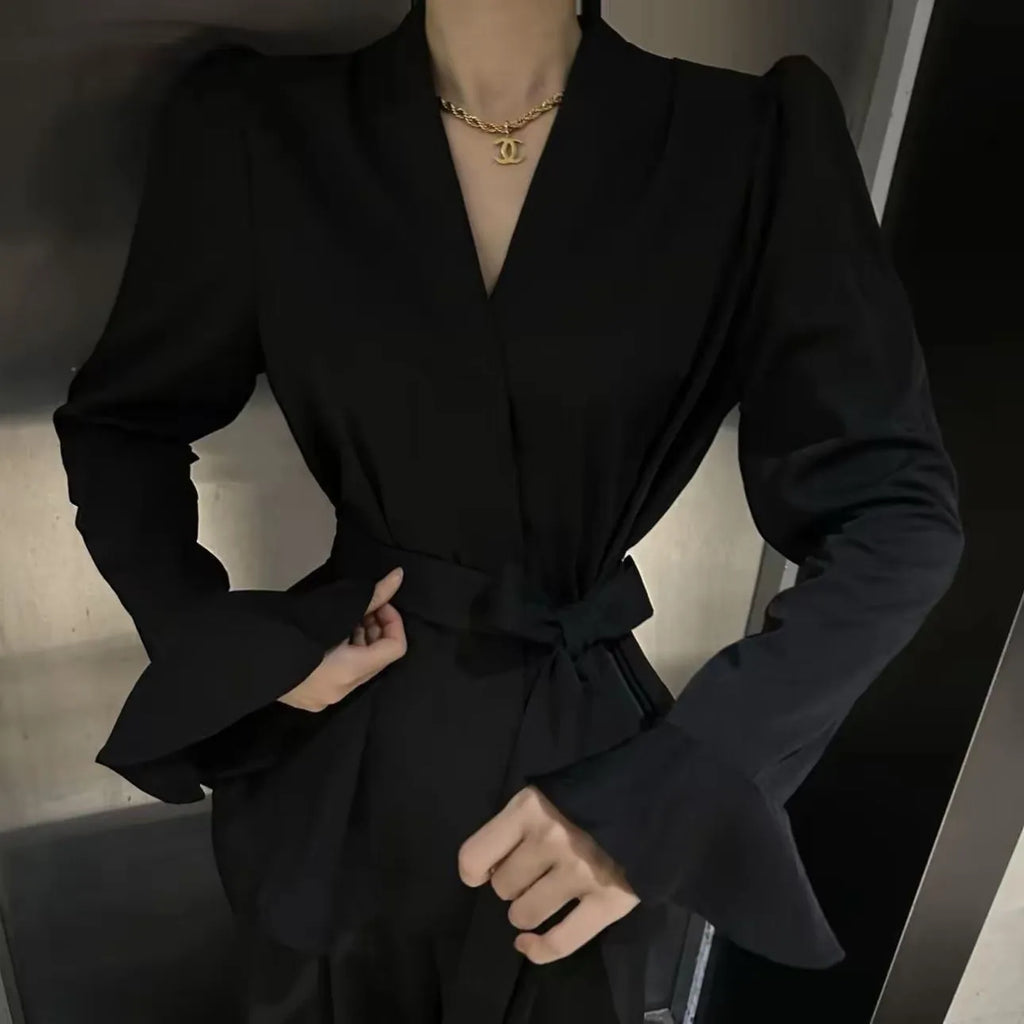 Women's black French-style shirt with irregular collar, tied front, and long bell sleeves.